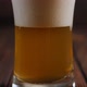Closeup of a Glass of Beer with Lots of Foam and Bubbles on a Wooden Background - VideoHive Item for Sale