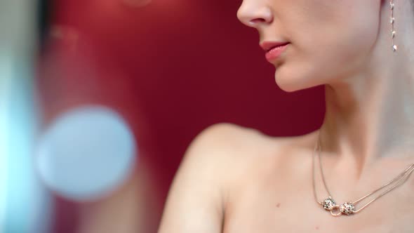 Closeup Bare Girl Neck in Jewelry Pose at Red Bokeh Interior