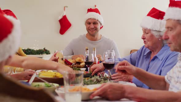 Caucasian family in santa hats sitting on dining table