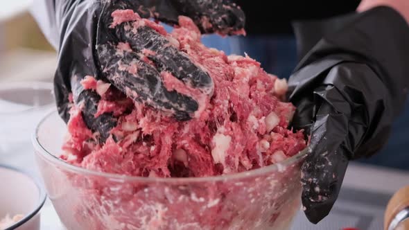 Kneading of Minced Meat with Onion and Spices in a Glass Bowl