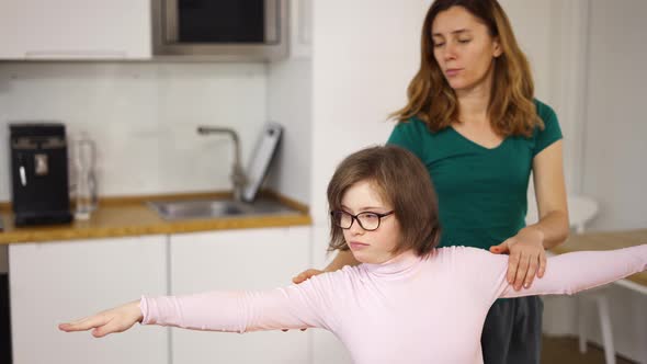 Girl with Down Syndrome and Her Mom Practicing Yoga Position at Home