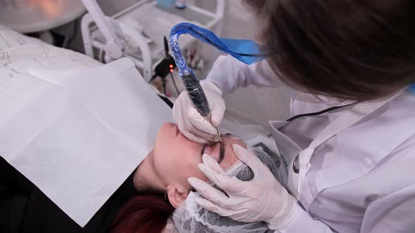 Permanent Makeup Master Sprays Paint on the Eyebrow