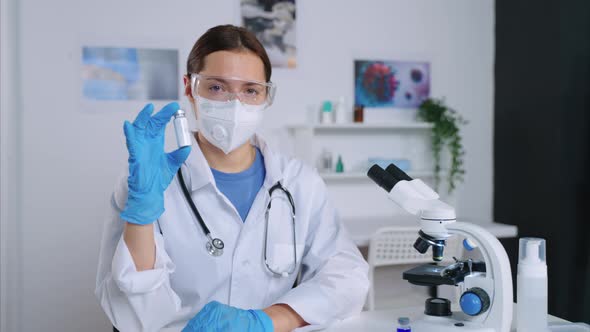 Young Female Therapist is Holding Vial with Modern Vaccine and Looking at Camera