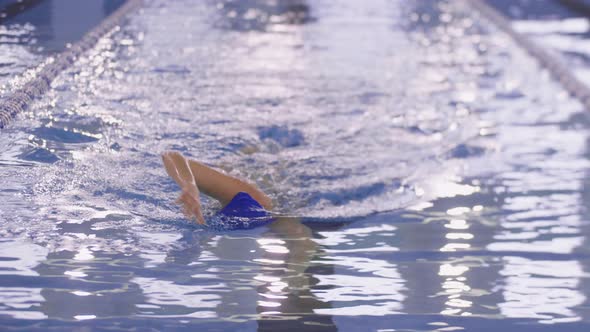 A Young Woman Swimmer Swims on a Track of an Indoor Pool