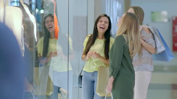 Female Friends Discussing Clothing Store Display