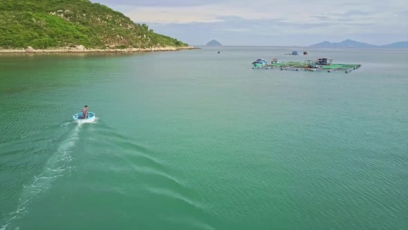 Aerial Round Motorboat Sails To Floating Farm in Azure Bay