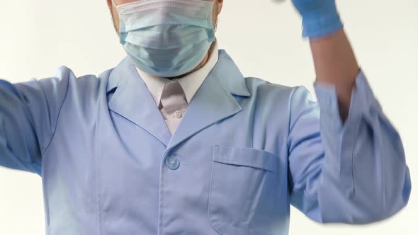 Young Doctor Stand and Hold Stethoscope in Hand in Blue Gloves