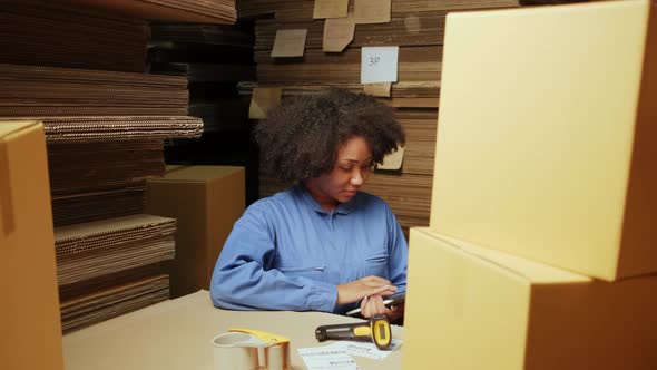One female worker scan bar codes to check orders at parcels warehouse factory.