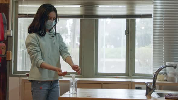 Corona pandemic Girl with face mask using hand sanitizer to prevent coronavirus