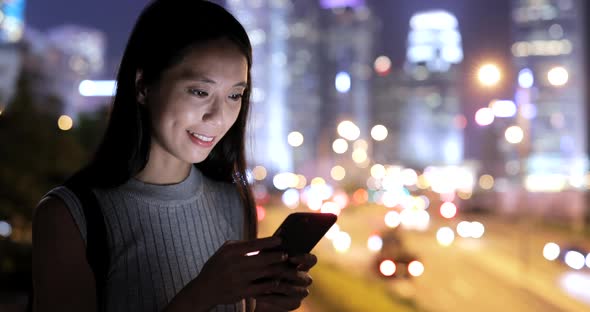 Woman looking at mobile phone in the city