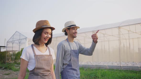 Happy two Asian couple farmers owner working in vegetables hydroponic farm with happiness.