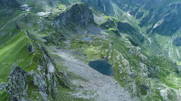 Moving Forward Over Majestic Alpine Mountain Valley with Lakes in Sunny Cloudy Summer