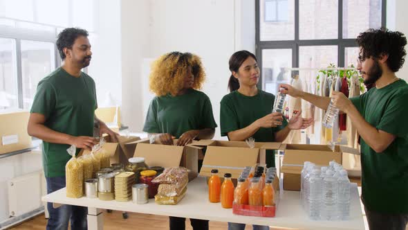 Happy Volunteers Packing Food in Donation Boxes