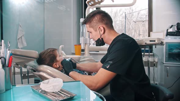 A Little Stressful Boy Getting His Teeth Done in the Modern Dentistry