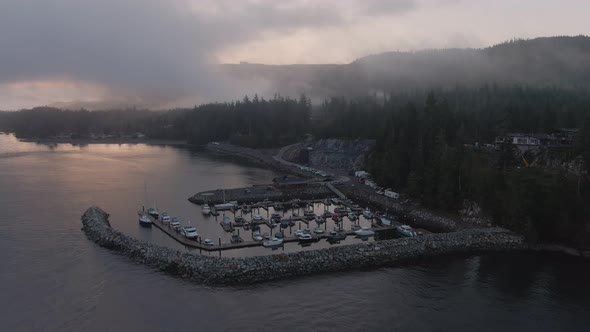 Aerial View of a small secluded town on the Pacific Ocean Coast during a cloudy summer sunrise. Take