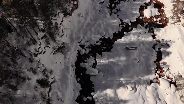 Aerial Slow Motion Over Snowcovered Coast Mountain River Stream