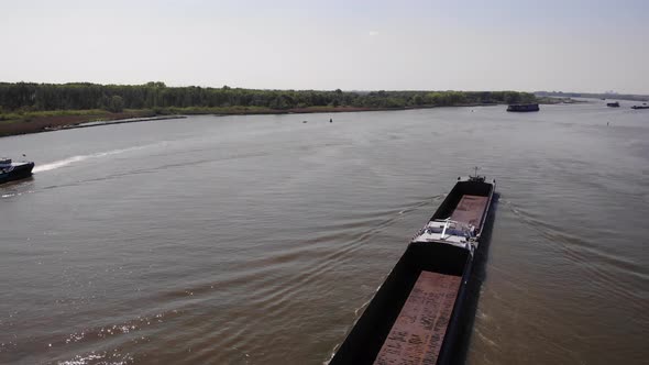 Bulker Ship With Empty Cargo Holds On Calm River At Summertime. - Aerial Pullback Shot