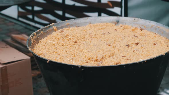 Prepare Wheat Porridge in a Traditional Large Cauldron Over an Open Fire