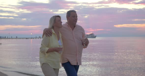 Couple having romantic seaside walk with wine