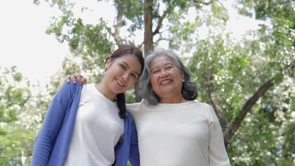 Elderly mother with happy Asian daughter smiling Take a walk and exercise in the park.