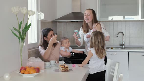 First birthday, mother lights a candle on the cake at home. Friends meet on a holiday with kids