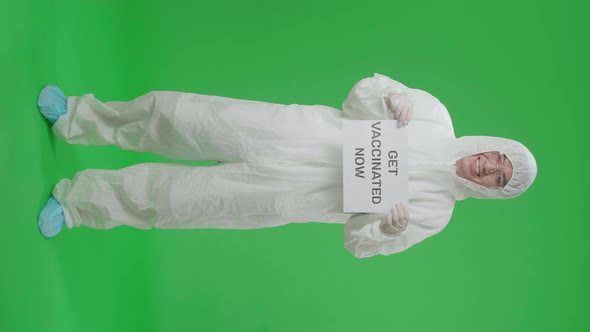 Full Body Of Asian Man Wear Uniform Ppe And Holding Get Vaccinated Now Sign In Green Screen Studio