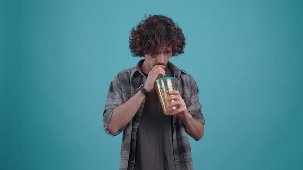 The Young Chalk Thirstily Drinks Juice From the Glass with the Straw After Which He Puts His Hand on