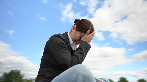 Frustrated Business Woman Closes Laptop on Cloudy Sky Background