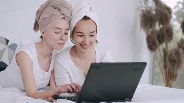 Two Girls Sitting at Home and Using Laptop