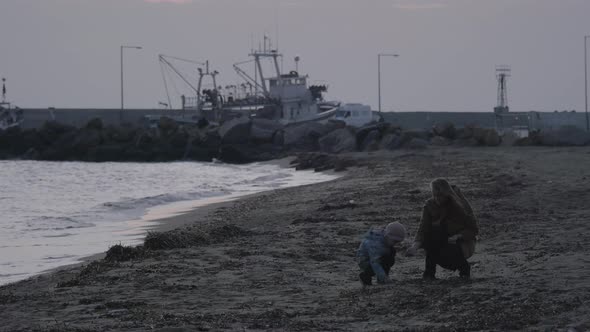 Mother and child throwing stones in the sea