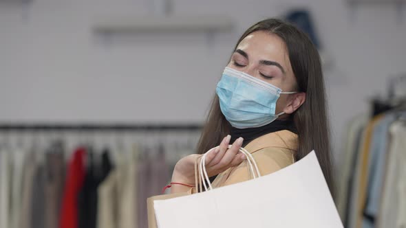 Portrait of Happy Satisfied Female Client in Covid19 Face Mask Looking at Camera Smiling Standing in