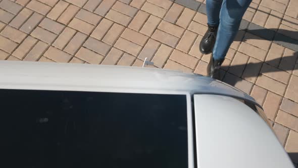View From the Roof of the Car Womans Hand Connecting a Power Supply Cable Charging Electric Car