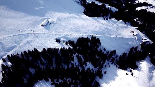 Ski in the Alps with ski lift and people skiing on the slope. Aerial view