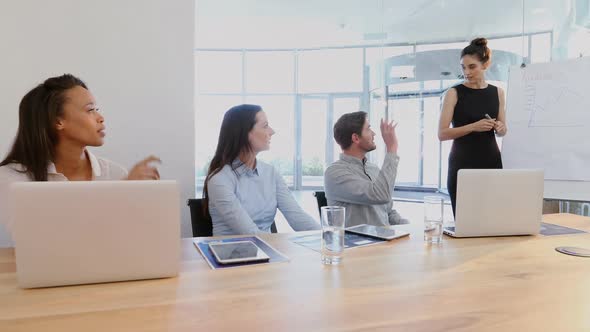 Female executive giving presentation to her colleagues in conference room 4k