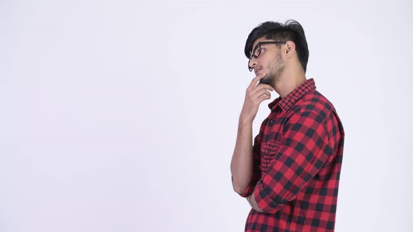 Profile View of Young Handsome Bearded Indian Hipster Man Thinking