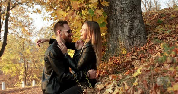 A Brutal Man with Sunglasses Has Joy with Beloved, They Kiss on a Stone Outdoors