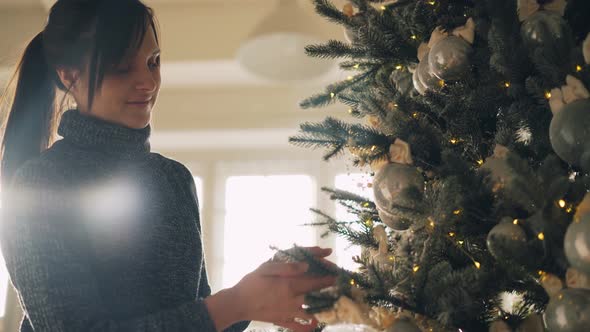 Happy Young Woman Is Decorating New Year Tree Getting Ready for Christmas Day at Home Creating