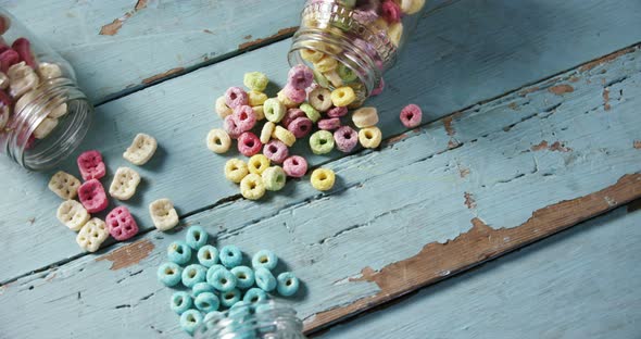 Scattered cereals from jar on wooden table 4k