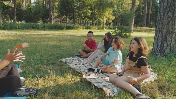 Teacher Spending Break After Classes Playfully with Pupils Outdoors