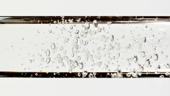 Macro Shot of Clear Water Air Bubbling By Pouring Water Inside Clear Pipette on White Background