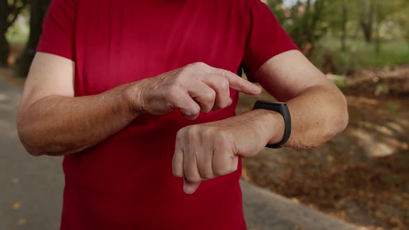 Adult Runner Man Starting Tapping Touchscreen on Smart Watch, Tracking Distance, Checking Pulse
