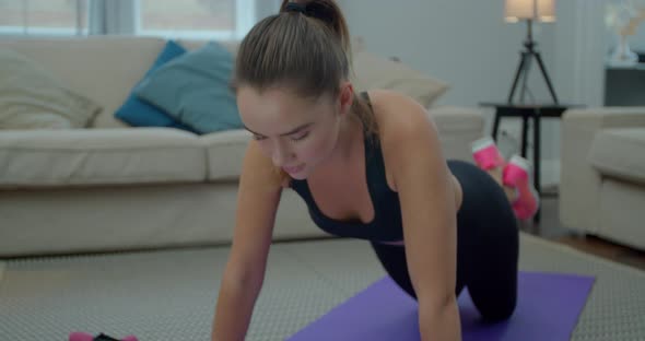 Young Sporty Woman Is Doing Push-ups Exersice at Home in Living Room. Athletic Fit Girl Is Doing