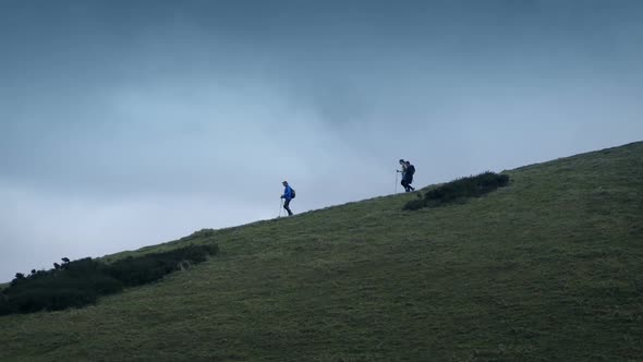Hikers Walk Down Hillside