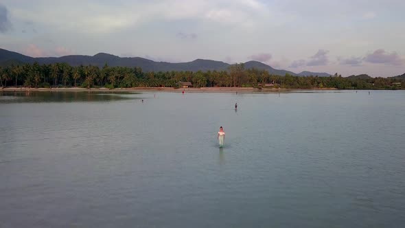 Young Asian Woman Walking Alone In the Sea at Beautiful Sunset Thailand