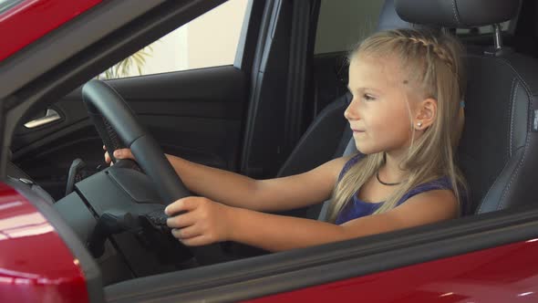 Baby Girl Sits at the Steering Wheel and Pretends To Drive