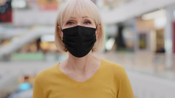 Closeup Mature Caucasian Woman in Protective Mask Standing Indoors Looking at Camera Worried Serious