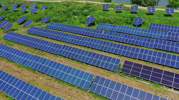 Innovative solar power station on field. Flight over solar collector sheets in countryside in sunny 