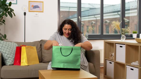 Happy Young Woman with Shopping Bag at Home