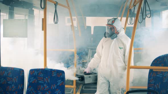 Disinfector Is Fumigating Bus Interior with a Special Machine