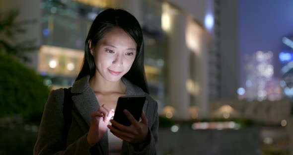 Business woman use of cellphone in city at night